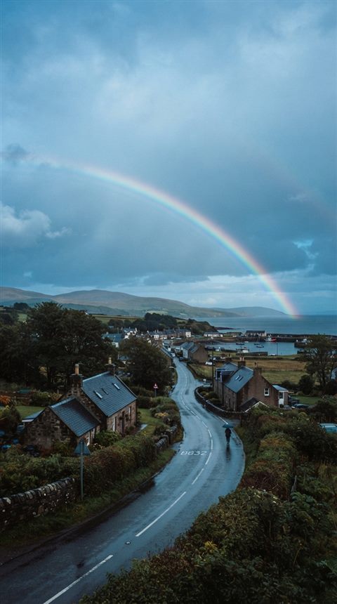 Cinematic film still of rainbow after the rain, wide shot with open space at the top for text, cool blue tones, quiet atmosphere, 9:16 aspect ratio