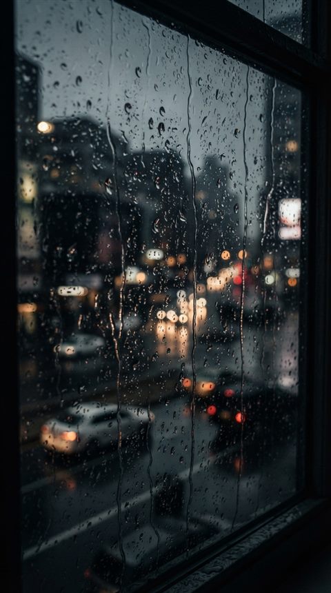 Photorealistic photo of Raindrops falling on a window pane with a blurred urban view in the background, close-up detail with shallow depth of field, moody dark tones, dramatic lighting, 9:16 aspect ratio