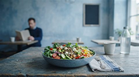 Photorealistic photo of healthy salad bowl, wide shot with open space at the top for text, cool blue tones, quiet atmosphere, 16:9 aspect ratio