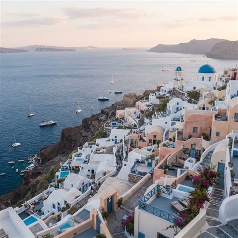 Photorealistic photo of white houses of Santorini above the sea, high-angle view from above, soft pastel colors, bright and cozy, 1:1 aspect ratio
