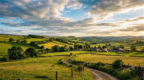 Cinematic film still of peaceful countryside scenery with rolling hills, wide shot with open space at the top for text, vivid colors, high contrast, energetic, 16:9 aspect ratio