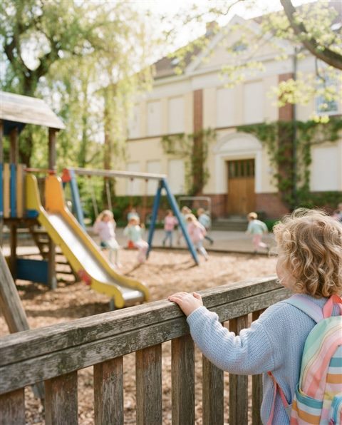 Cinematic film still of a school building with a playground, close-up detail with shallow depth of field, soft pastel colors, bright and cozy, 4:5 aspect ratio