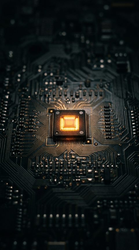 회로기판 위에서 빛나는 반도체 칩, 시네마틱 영화 장면, 단순하고 깔끔한 구도 가운데 놓인 피사체, 어두운 톤, 극적인 조명, 9:16 비율