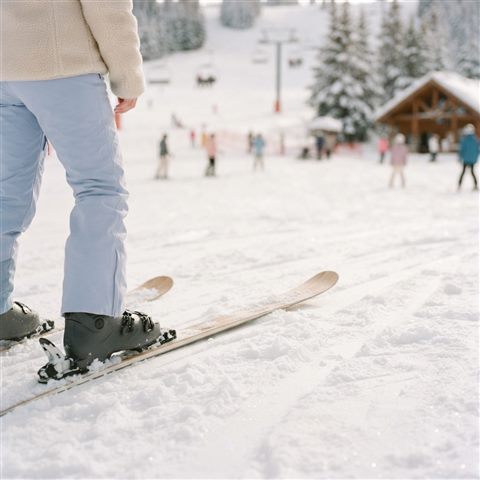 Photorealistic photo of a snowy ski slope, close-up detail with shallow depth of field, soft pastel colors, bright and cozy, 1:1 aspect ratio