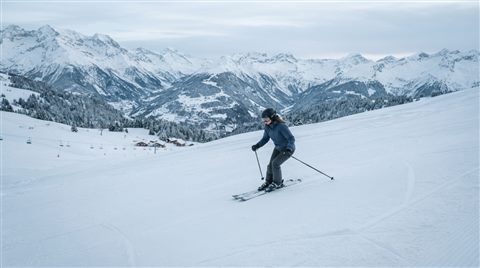 Photorealistic photo of a snowy ski slope, centered subject with a simple uncluttered composition, cool blue tones, quiet atmosphere, 16:9 aspect ratio