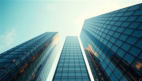 Photorealistic photo of Looking straight up at modern glass skyscrapers piercing a bright blue sky., centered subject with a simple uncluttered composition, warm golden light, calm mood, 16:9 aspect ratio