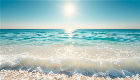 Photorealistic photo of Crystal clear turquoise ocean water gently washing onto white sandy shores under a brilliant summer sun., wide shot with open space at the top for text, warm golden light, calm mood, 16:9 aspect ratio