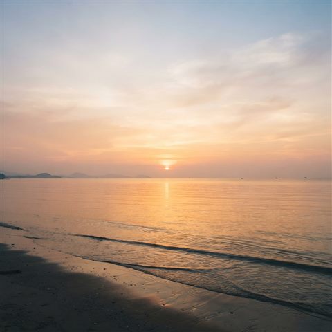 Soft 3D render of Realistic photo of a golden sunset over a calm ocean viewed from eye level, with empty sky space on top for text, horizontal landscape format, wide shot with open space at the top for text, misty morning haze, dreamy, 1:1 aspect ratio