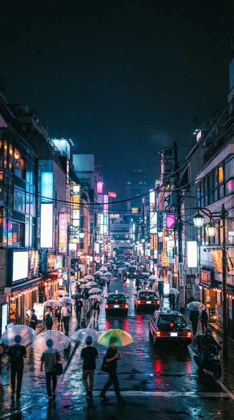 Cinematic film still of a Tokyo street at night, wide shot with open space at the top for text, vivid colors, high contrast, energetic, 9:16 aspect ratio