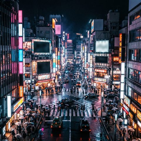 Photorealistic photo of a Tokyo street at night, high-angle view from above, vivid colors, high contrast, energetic, 1:1 aspect ratio
