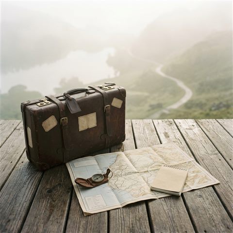 Photorealistic photo of travel suitcase and map, high-angle view from above, misty morning haze, dreamy, 1:1 aspect ratio
