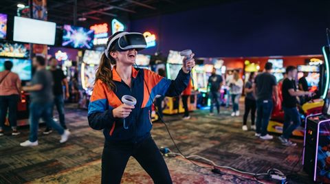 Photorealistic photo of a person wearing a VR headset, wide shot with open space at the top for text, vivid colors, high contrast, energetic, 16:9 aspect ratio